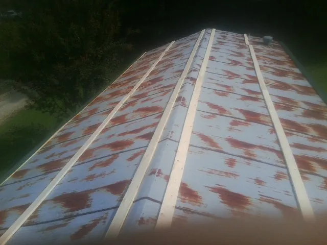 Rusted metal roof panels with new wood purlins before replacement — Storm Damage Roof Repair in Meservey by Roofing Brothers