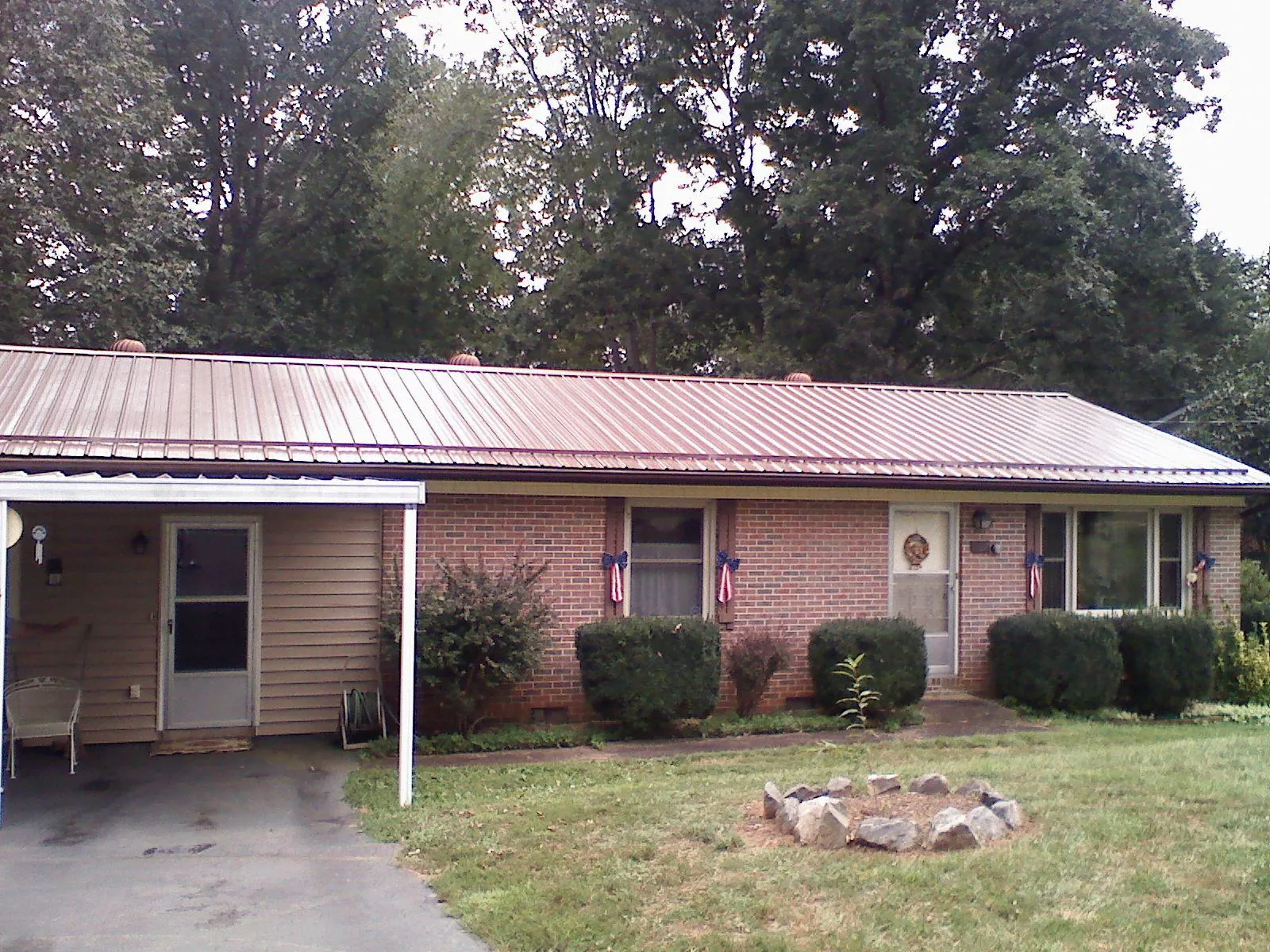 Bronze metal roof and carport on a brick ranch home — Roof Repair work by our crew in Meservey